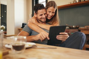 Loving Young Couple Catching Up On Social Media Smiling