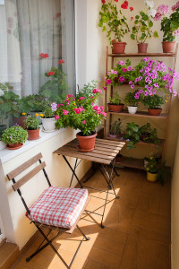 Beautiful balcony with small table, chair and flowers.