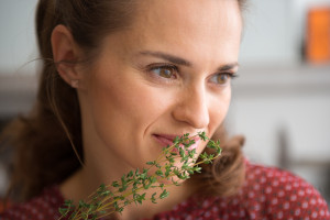 Closeup Of Woman Smelling Fresh Thyme