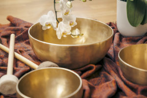An image of some singing bowls and a white orchid