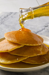 Agave Syrup Pouring On A Plate Of Pancakes.