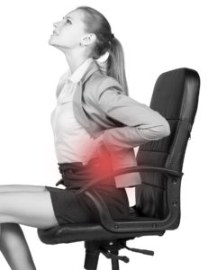 Businesswoman with lower back pain, sitting on office chair