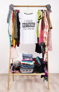 Many Clothes On The Rack With A T-shirt Saying Nothing To Wear.