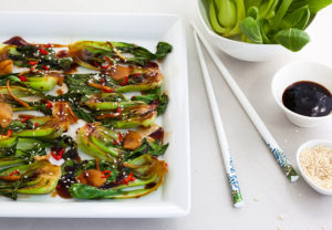 Roasted baby bok choy with spicy sauce and sesame seeds
