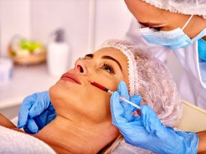 Woman middle-aged in spa salon with beautician. Female giving li