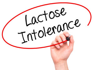 Man Hand writing Lactose Intolerance with black marker on visual screen. Isolated on background. Business technology internet concept. Stock Photo